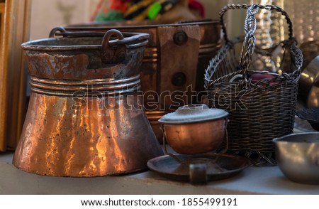 Antiques, a brass ice bucket, a candlestick, an old basket. Household items that are waiting for their second owner. Royalty-Free Stock Photo #1855499191