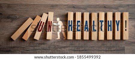 Pieces of wood with Healthy and Unhealthy on wooden background
