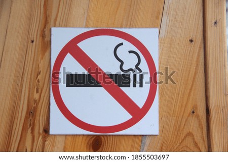 No smoking sign on wooden wall, concept of health care, smoking cessation. Smoking cigarette in a crossed out red circle. Stock photo with empty space for text.