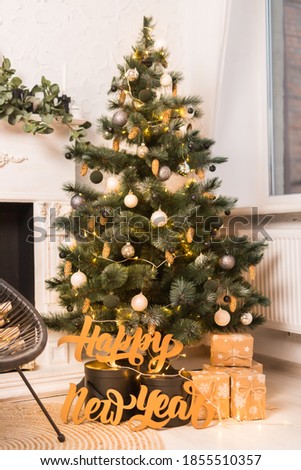 Holidays location with tree, black and brown presents and garlands. Concept of Christmas and New Year