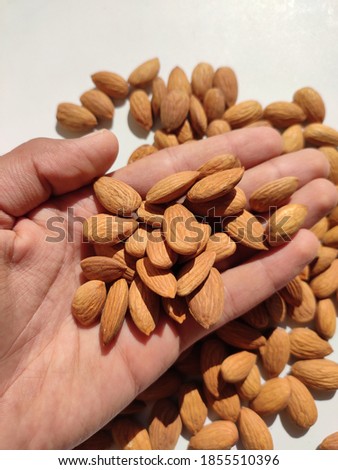 uttarakhand,india-3 may 2020:almonds on hand.this is a picture of almonds on white background.almonds are good for brain and health. 