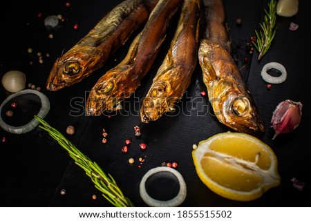 Golden smoke-dried fish close up,on black background.