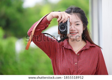 Cute Asian Thai teen girl enjoy with digital camera for hobby photographer.