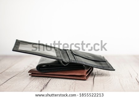 open leather wallet on stacks of leather wallets over white background
