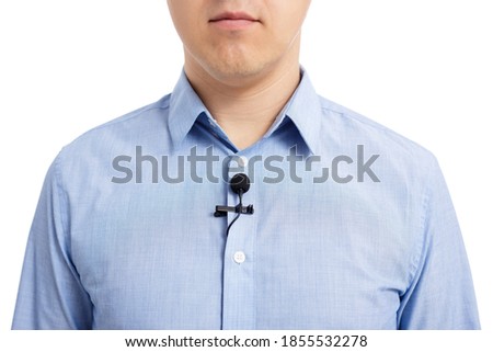 interview or broadcasting concept - close up of small lavalier microphone on male shirt