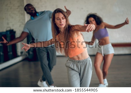 Dance class. A woman learning hip-hop choreography with her groupmates Royalty-Free Stock Photo #1855544905