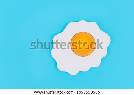 Fried egg on pastel blue background,minimal koncept