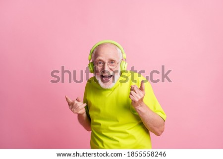 Photo of crazy old man listen music dance wear headphones spectacles lime color clothes isolated on pink background