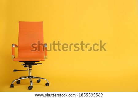 Modern office chair on yellow background. Space for text Royalty-Free Stock Photo #1855595569