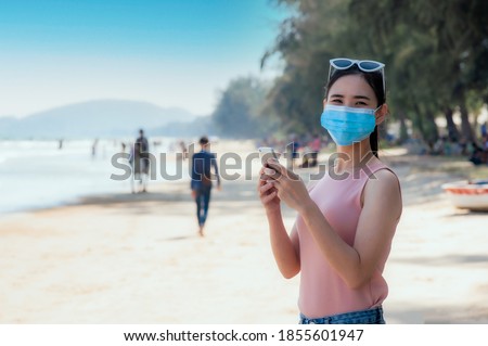 Asian women and face mask travel on beach at Phuket sea Thailand