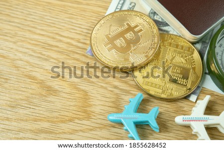 passport and bitcoins on wood table for travel content.
