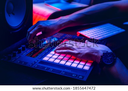 Music producktion MIDI conrloller pad operated by the producer in the home sound studio. Royalty-Free Stock Photo #1855647472