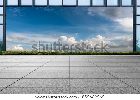 The sky behind the glass curtain wall frame in front of the Marble Square
