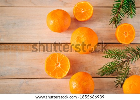 Fir branches and tangerines on wooden background. Christmas and new year concept. Place for text.