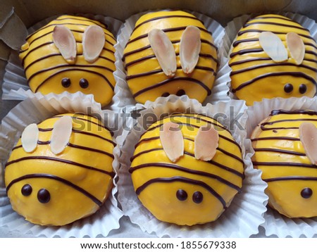 Selectively focus on donuts.  Donuts are a food that many people love.  Fans ranging from children to adults.  There are several kinds of flavors such as chocolate, cheese and others.   