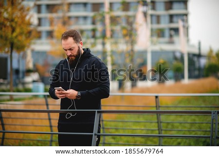 Young  man with beard  taking break from exercising outdoors