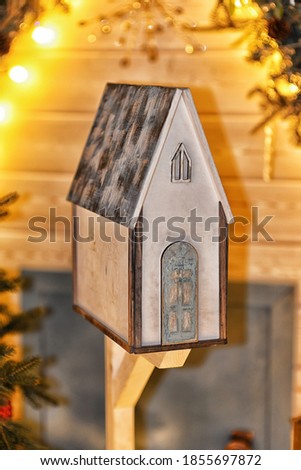 
wooden little house on the background of christmas lights