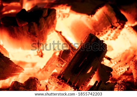 Hot fireplace full of wood. Real Flames from burning logs texture background. Fireplace background. Fire flame close up.	
