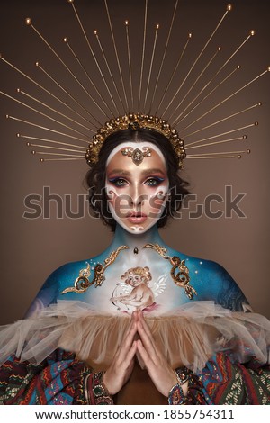 Portrait of a girl with gold and blue creative art make-up. Photo taken in the studio. Renaissance Royalty-Free Stock Photo #1855754311