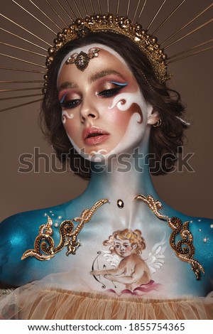 Portrait of a girl with gold and blue creative art make-up. Photo taken in the studio. Renaissance Royalty-Free Stock Photo #1855754365