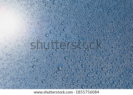 Water droplets on glass in the sky background.