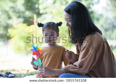 Asian girls and mothers are resting and doing holiday activities in the park, a warm family concept and mother's love.