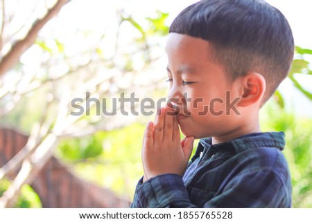Little Boy praying in the morning .Little asian boy hand praying, Kid praying to God,Hands folded in prayer concept for Christianity, faith, spirituality and religion.