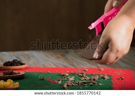 hands slicing chocolate on a table. making panettone for christmas