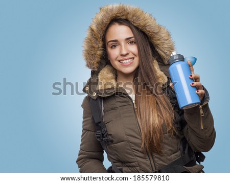 Young woman hiker holding blue water bottle