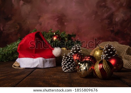 Christmas themed arrangement with beanie balls and pine cones in the background arranged over rustic wood, selective focus.