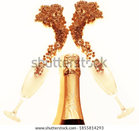 Golden stars confetti are spilled with splashes of champagne from a glass lying on blue background. The symbol of the holiday of Christmas and New Year.empty Copy space, flat  lay.bottle of champagne 