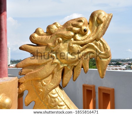 Golden head of a dragon statue at a Chinese temple