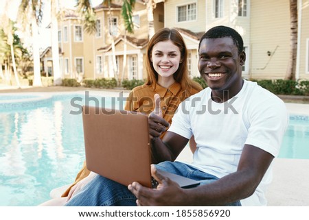 man and woman outdoors with laptop communication