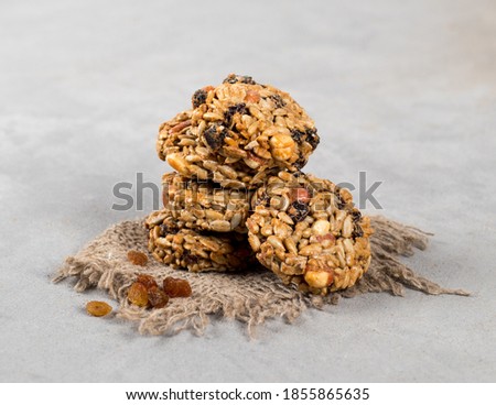 Energy sweets made from peanuts, raisins and sunflower seeds on a linen napkin on a light background