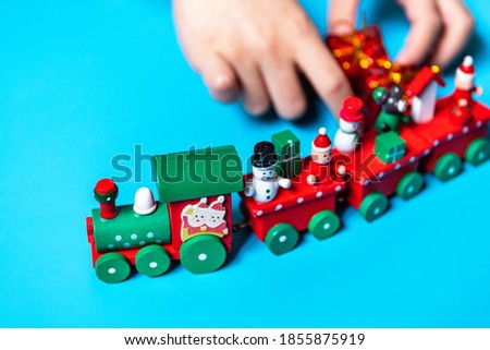 Kid playing with christmas toy train.