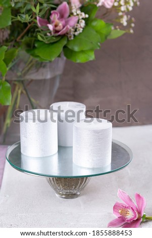 On the table are silver candles and a flower