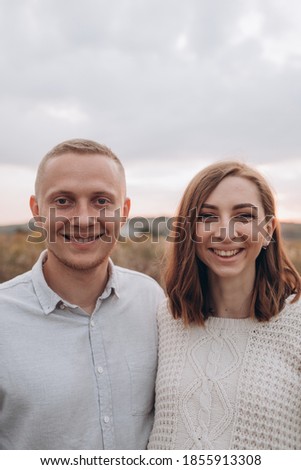 Happy young pregnant couple walking on a mountain