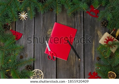 DIY Christmas and happy New year greeting card.On a wooden table with tree branches,red paper mitten with a white snowflake.Christmas instructions.decorations.Gifts.Step by step.Flat lay.Top view