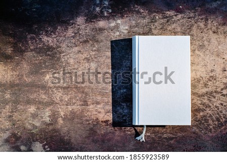 Closed gray book seen from above on rustic wood
