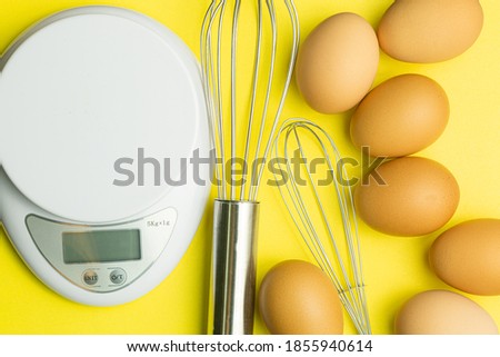 Chicken eggs, brown eggs, broken egg in carton box on yellow background. Top view natural eggs in carton box product concept,