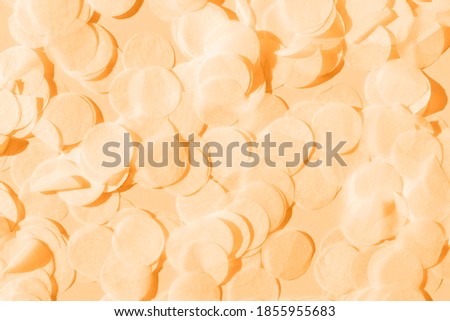 orange paper confetti on a pastel peach background perfect bridal backdrop toned trendy color marigold