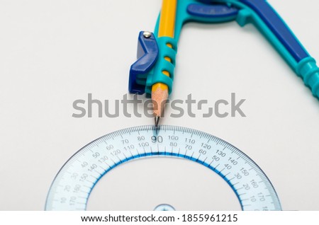A math concept, close up of a pencil, compass, and protractor