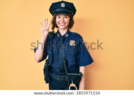 Young beautiful woman wearing police uniform showing and pointing up with fingers number four while smiling confident and happy. 