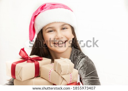Happy smiling child girl Santa with Christmas boxes on white background