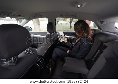 businesswoman dressed in jacket doing a face time from the car