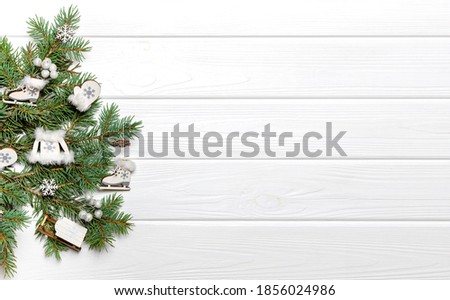 Pine branches and wooden ornaments on white background. New Year poster template, copy space