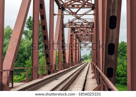 Old rusty railway bridge over the river.