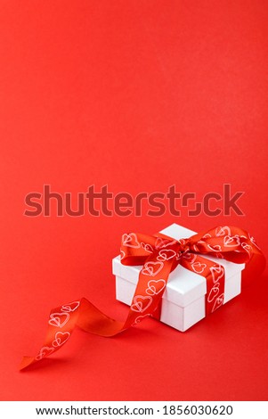 White Gift Box with ribbon Red Background Valentines Day Present.Copy space.
