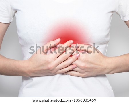 Hand holding pain point, suffering from heart or solar plexus ache. Royalty-Free Stock Photo #1856035459