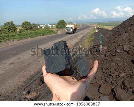 Coal mining : coal miner in the man hands of coal background. Picture idea about coal mining or energy source, environment protection. Industrial coals. Volcanic rock. Panorama photo

